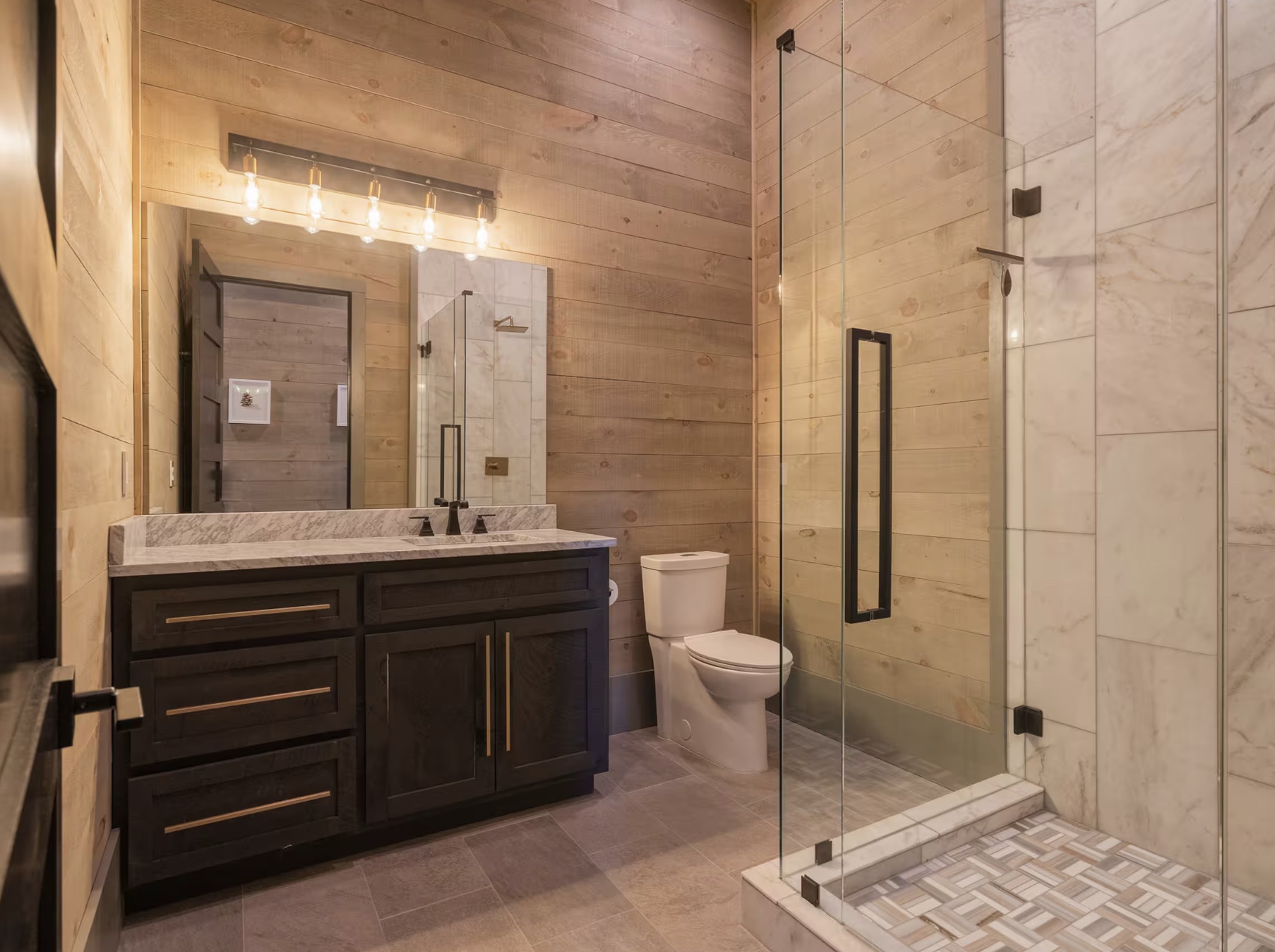 Wood-panelled bathroom with marble vanity and walk-in shower