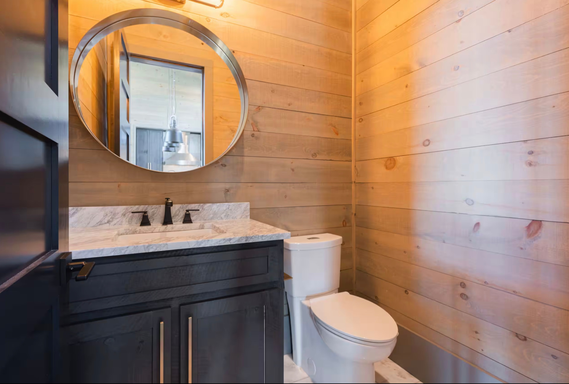Bathroom with dual vanities, rectangular mirrors, and brass lighting