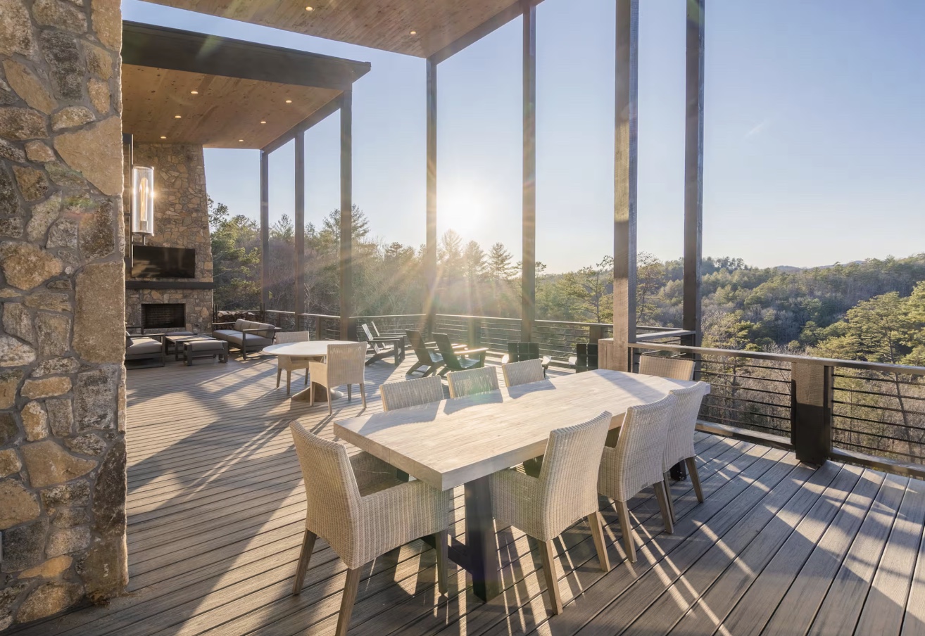 Outdoor dining terrace with stone fireplace overlooking the North Georgia hills